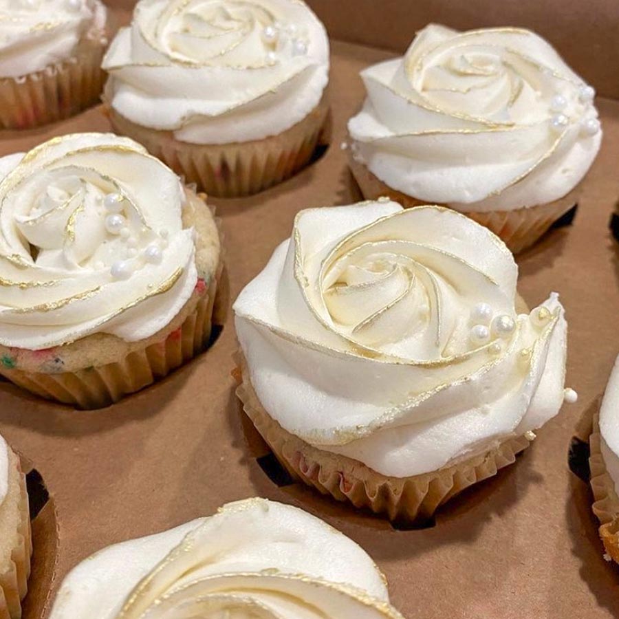 box of white icing cupcakes and white pearls